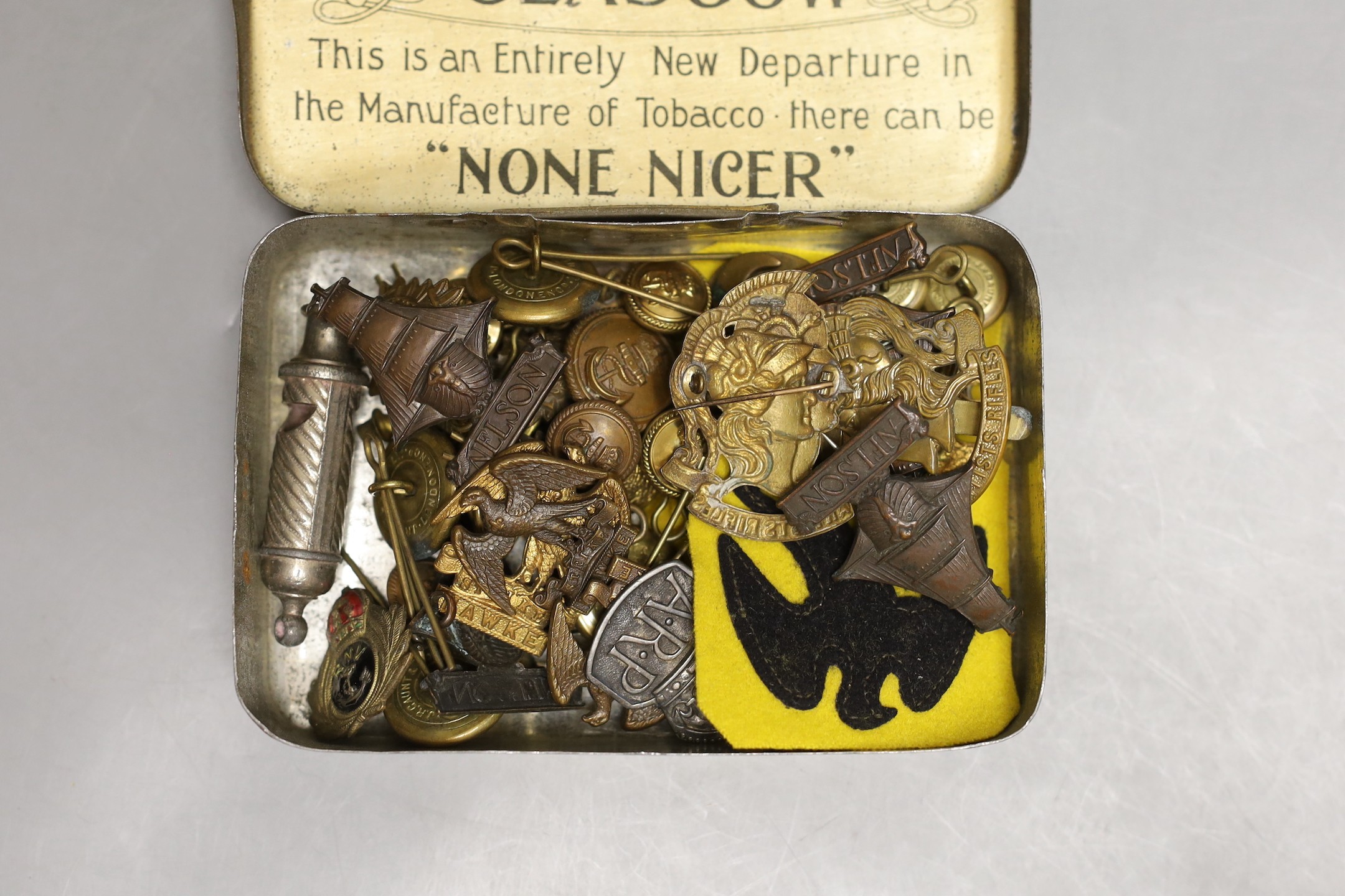 A collection of mixed cap badges and whistle